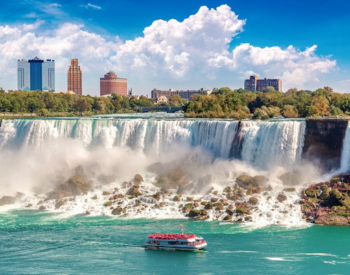 Hornblower Cruise boat approaching Niagara Falls, Canada with mist rising from the waterfall.