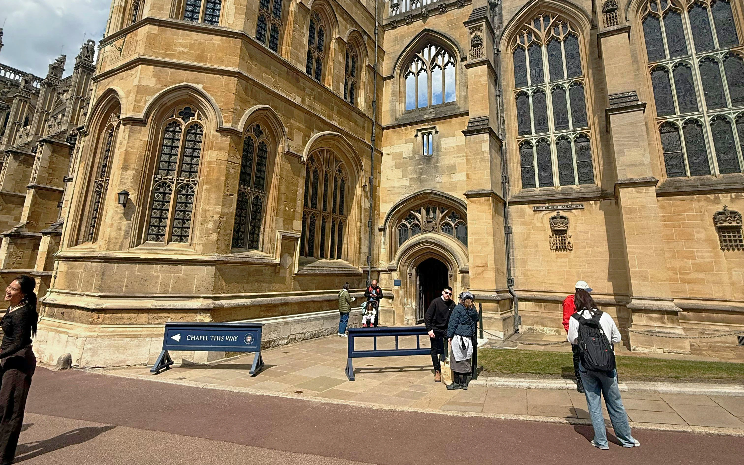 Visitors outside St George's Chapel, Windsor, near entrance with Gothic architecture.