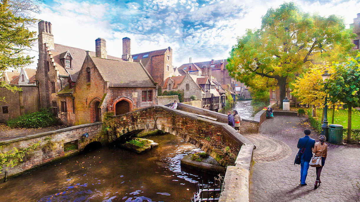 Boniface Bridge over canal in Bruges historic city center, Belgium, with people walking nearby.