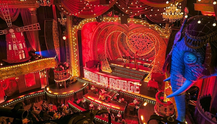 Tourists enjoying champagne at a Moulin Rouge show in Paris.