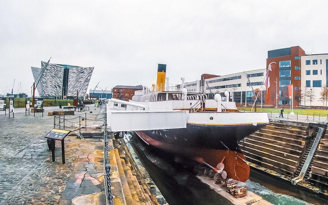 Titanic museum shipyard with historic ship and modern building in Belfast.