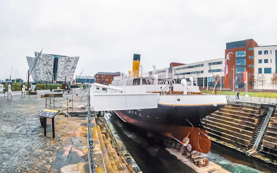 Titanic museum shipyard with historic ship and modern building in Belfast.