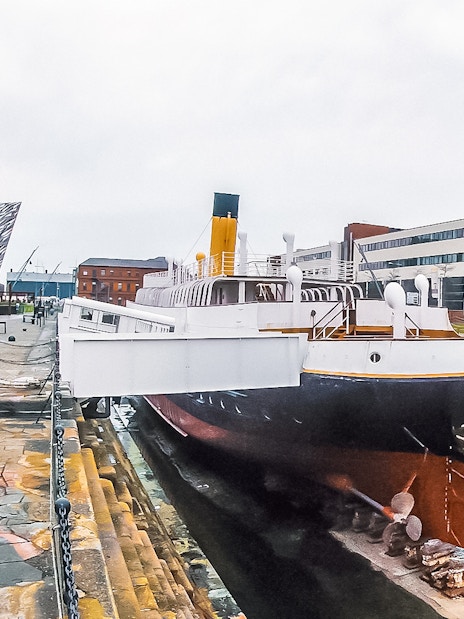 Titanic museum shipyard with historic ship and modern building in Belfast.