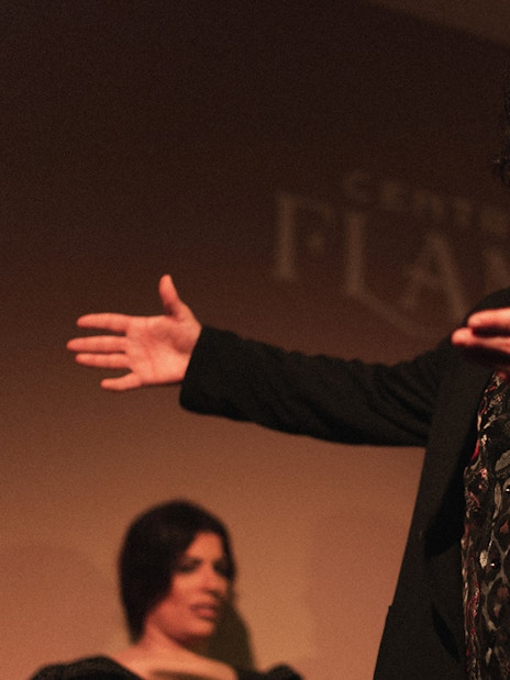 Flamenco performer gesturing passionately during a tablao show in Madrid.