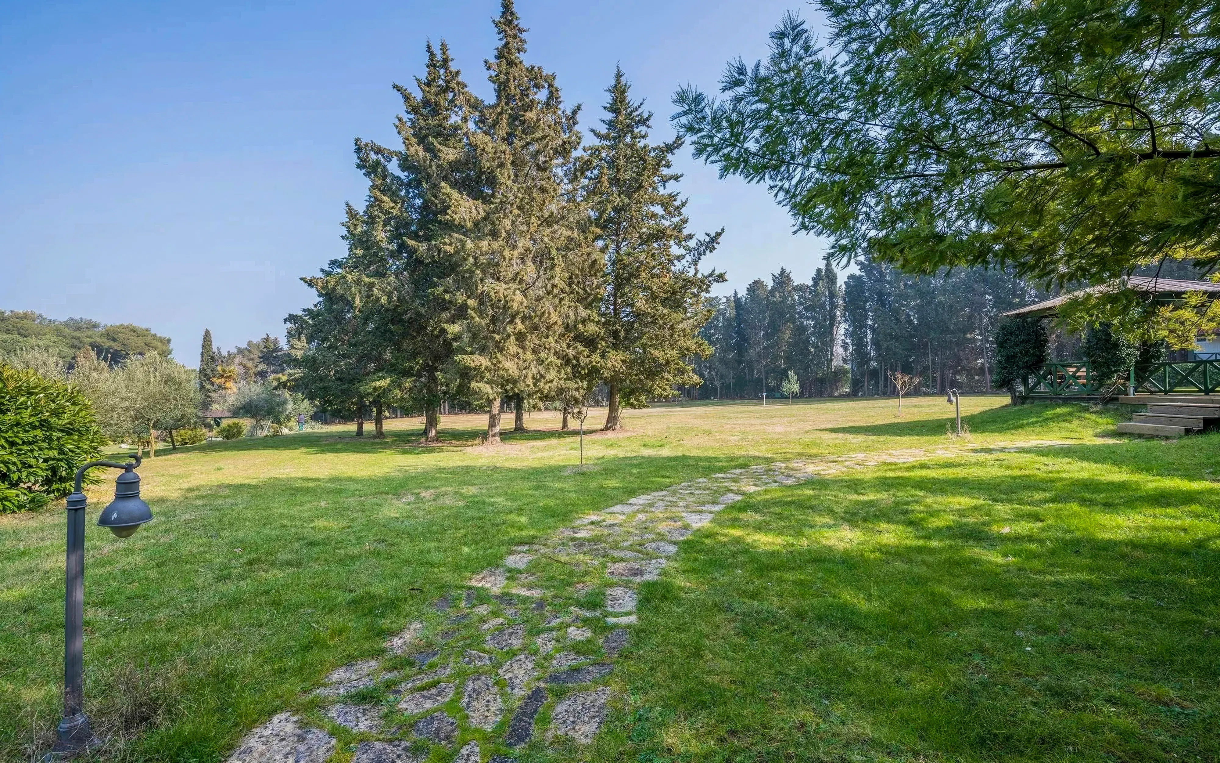 Stone path through grassy area with trees in Brijuni National Park, Croatia.