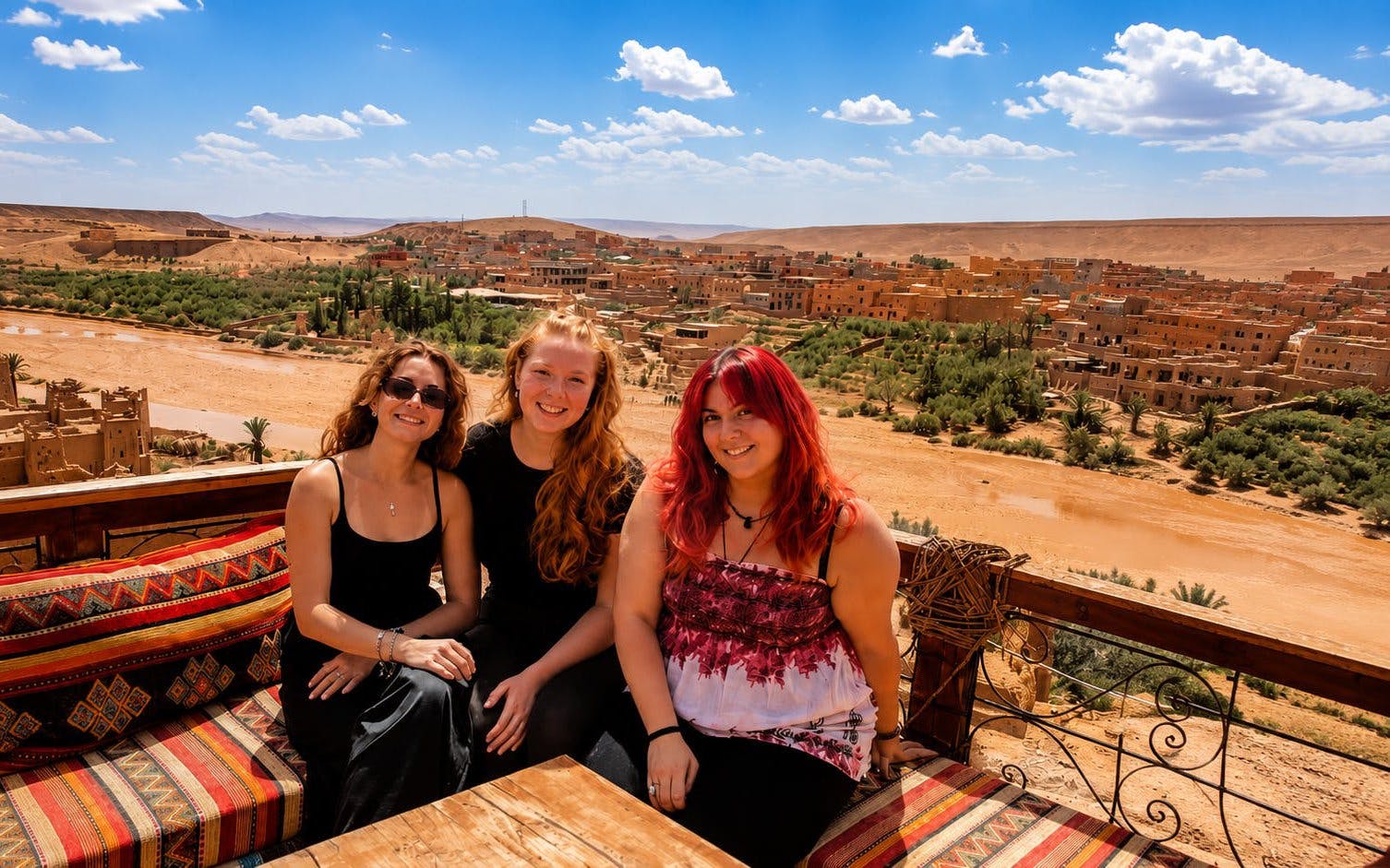 Scenic view of Aït Benhaddou village with three people seated in Marrakech, Morocco.