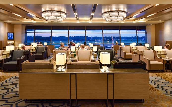 Plaza Premium Lounge seating area with travelers at Singapore airport.