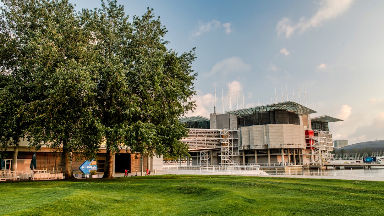 Lisbon Oceanário exterior with surrounding greenery and water.