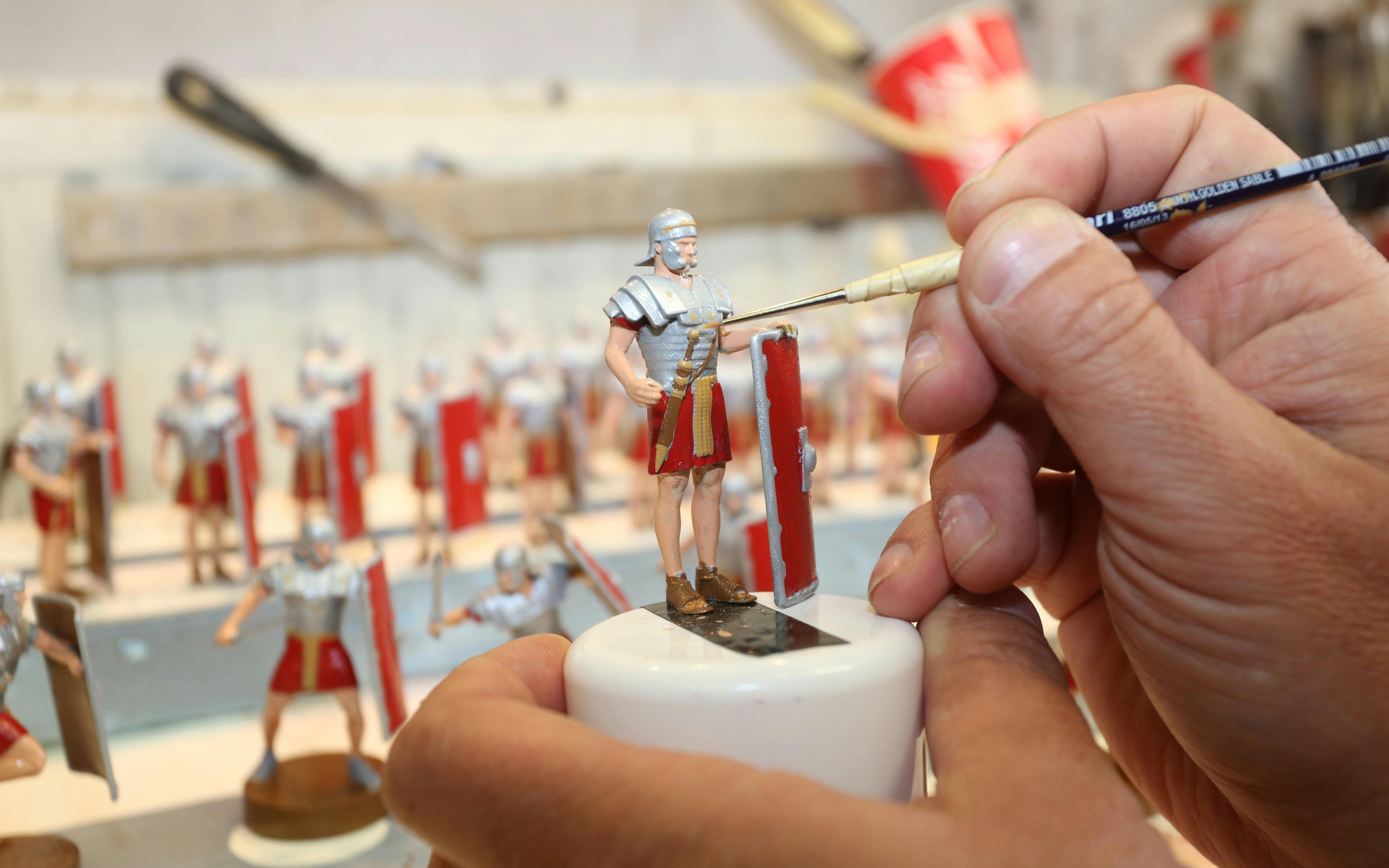 Painting miniature Roman soldier figurine at Mini-Europe, Brussels.