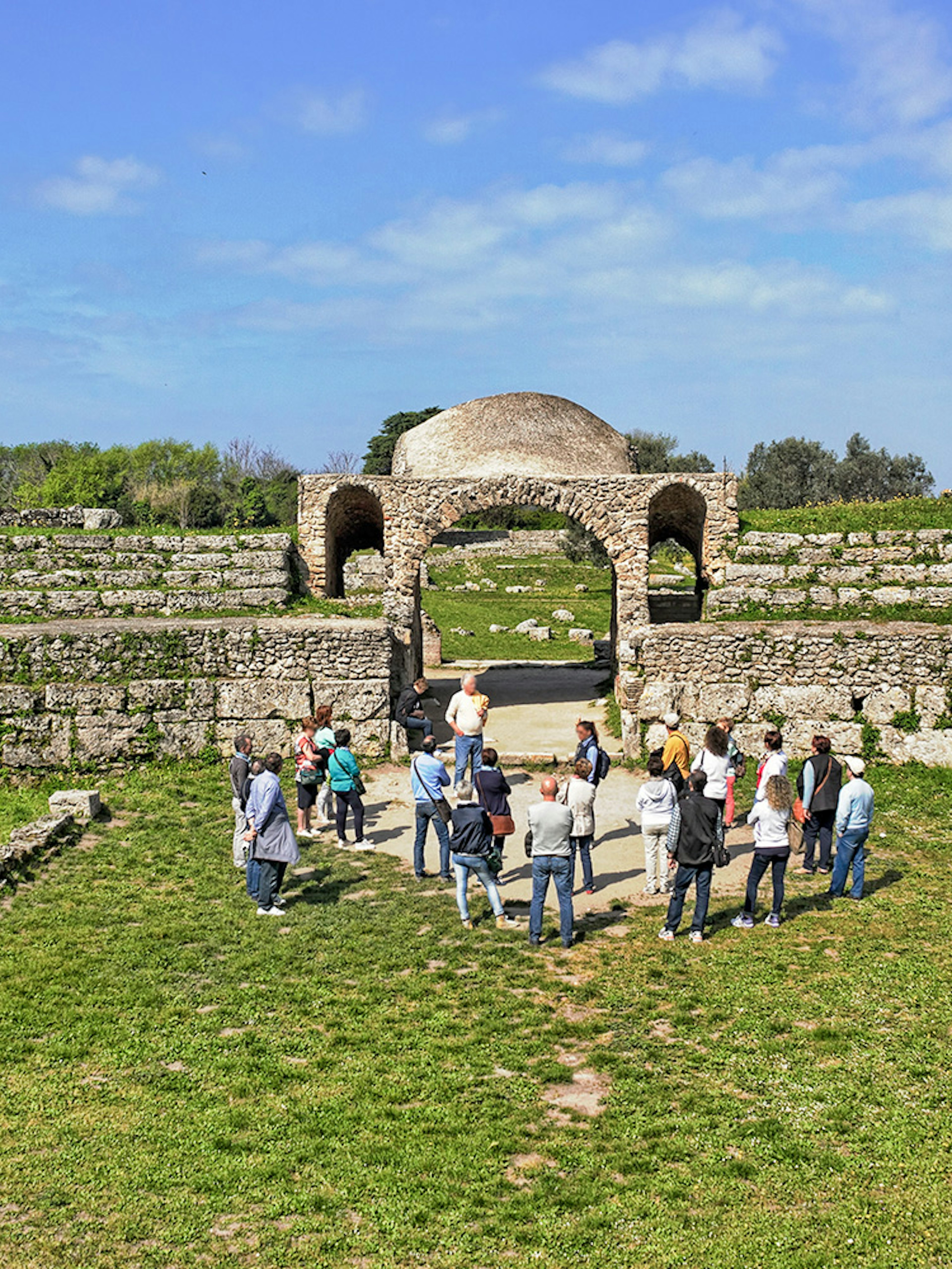 Visitors exploring ancient ruins at the Archaeological Park of Paestum, Italy.
