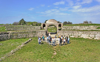 Visitors exploring ancient ruins at the Archaeological Park of Paestum, Italy.