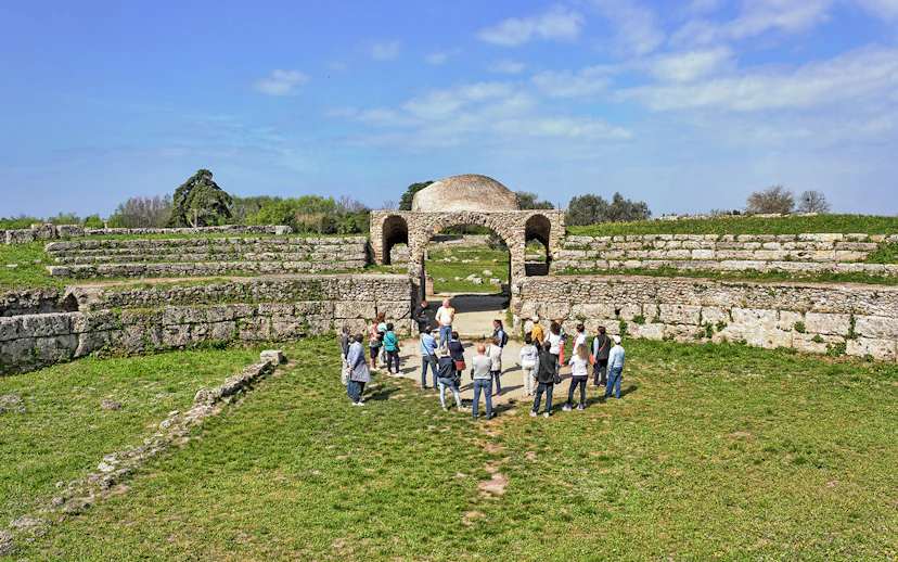 Visitors exploring ancient ruins at the Archaeological Park of Paestum, Italy.