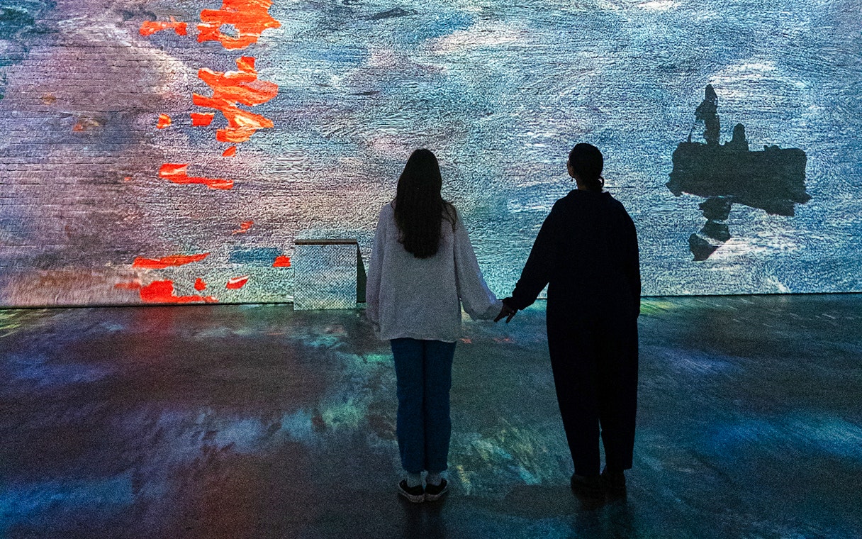 Visitors viewing Monet projections at Fabrique des Lumières exhibition.