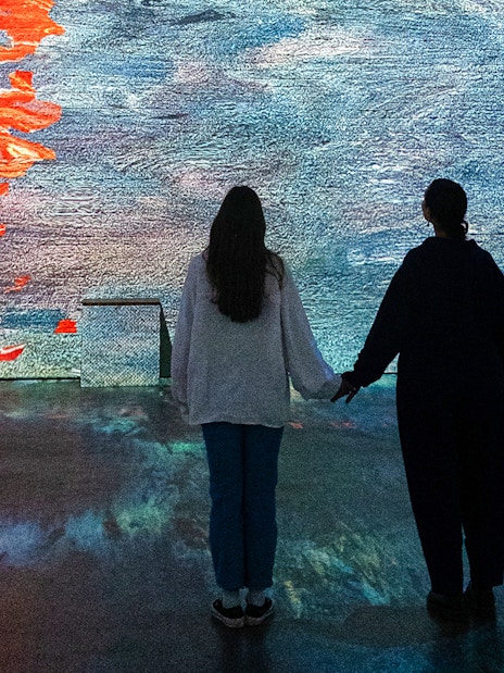 Visitors viewing Monet projections at Fabrique des Lumières exhibition.