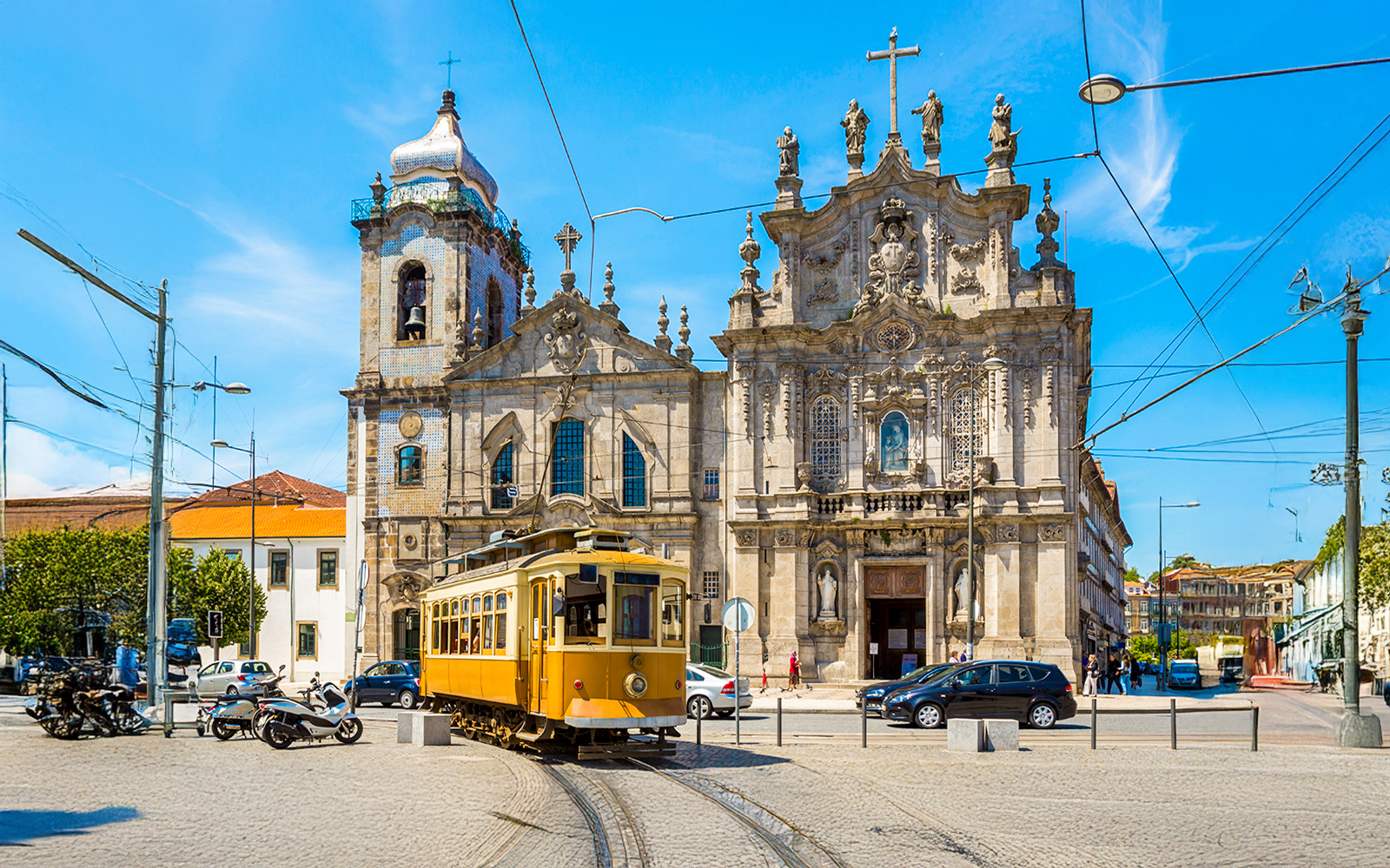 Yellow tram passing Carmo and Carmelites Churches in Porto, Portugal.