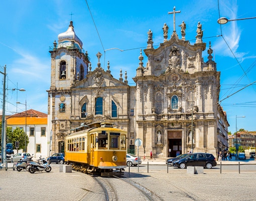 Yellow tram passing Carmo and Carmelites Churches in Porto, Portugal.