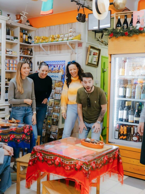Group reacting to dish presented by chef during Lisbon food tour.