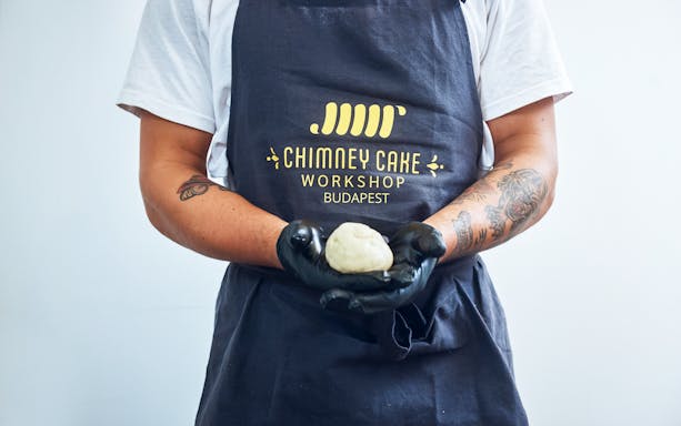 Chimney Cake Workshop participant holding dough in Budapest.
