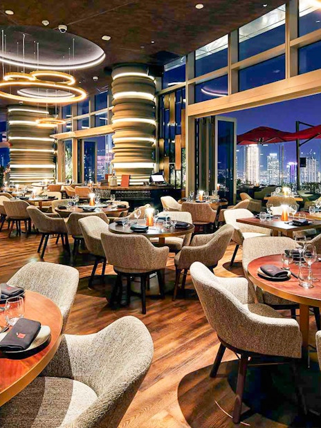 Luxurious dining area at CLV restaurant with city skyline view.