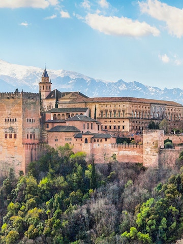 Alhambra palace complex in Granada with Sierra Nevada mountains in the background.