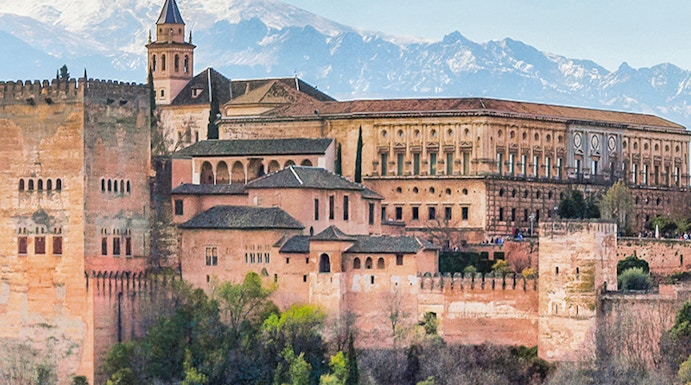 Alhambra palace complex in Granada with Sierra Nevada mountains in the background.