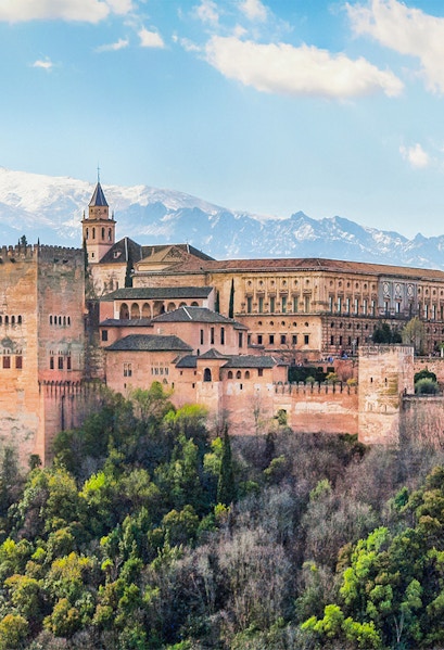 Alhambra palace complex in Granada with Sierra Nevada mountains in the background.