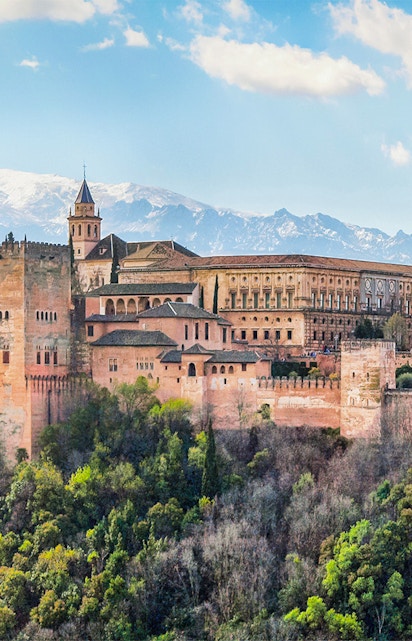 Alhambra palace complex in Granada with Sierra Nevada mountains in the background.