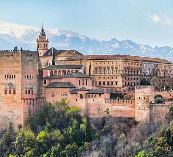 Alhambra palace complex in Granada with Sierra Nevada mountains in the background.