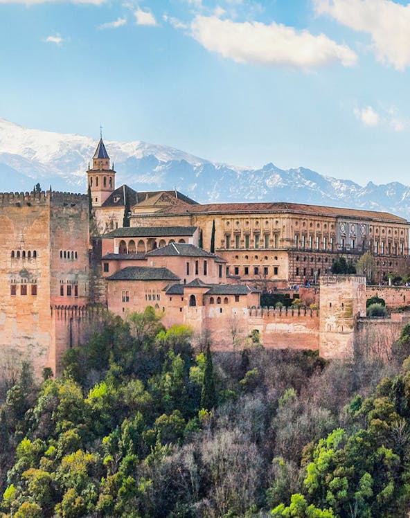 Alhambra palace complex in Granada with Sierra Nevada mountains in the background.