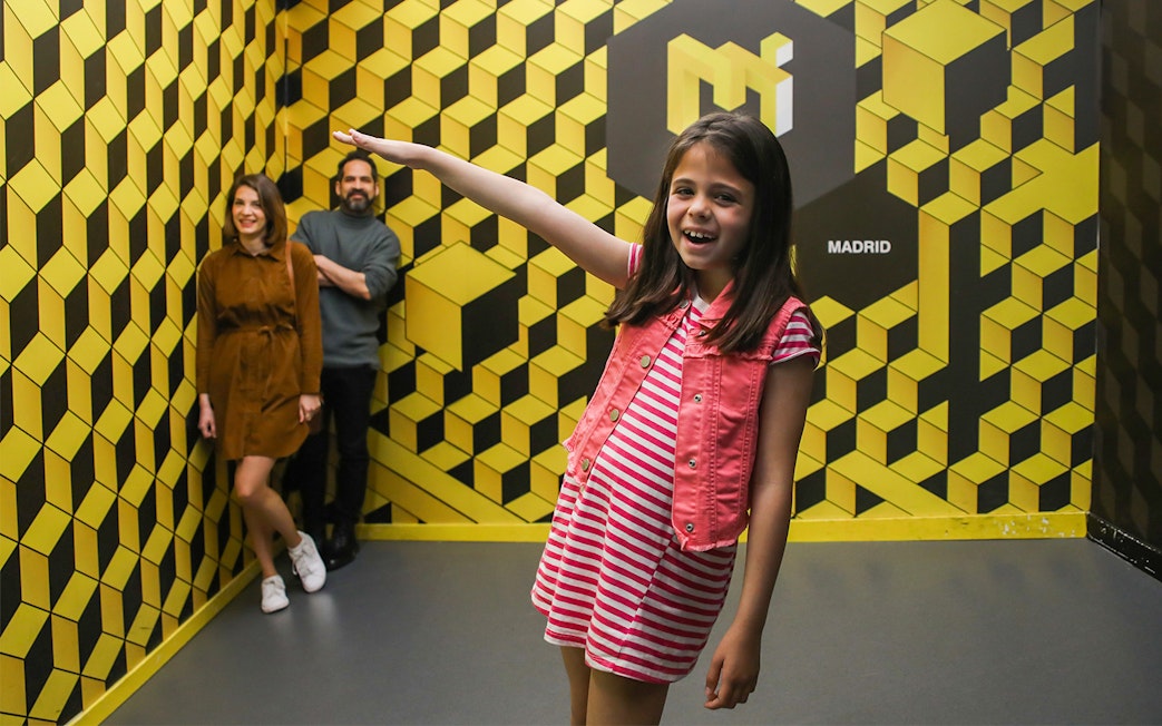 Visitors enjoying an optical illusion at the Museum of Illusions in Madrid.