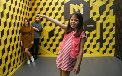 Visitors enjoying an optical illusion at the Museum of Illusions in Madrid.
