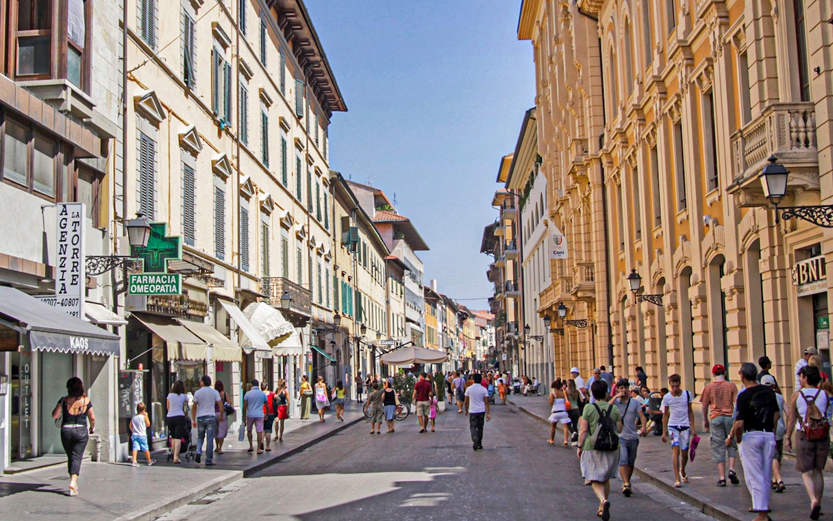 Pisa street scene with tourists walking, part of a 3-hour guided tour.
