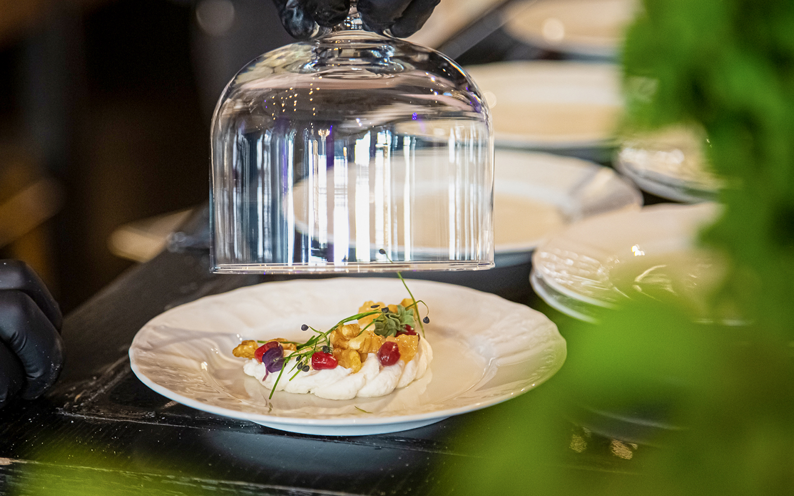 Czech tapas dish with garnishes under a glass cloche during tasting event.