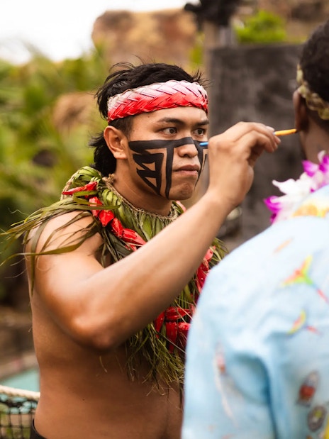 Performer applying face paint at Chief's Luau, Oahu, Hawaii.