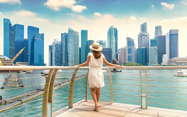 Woman overlooking Marina Bay Sands skyline in Singapore.