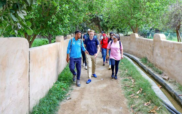 Group walking on a path at Hatta Farms during a mountain bike and hike tour.