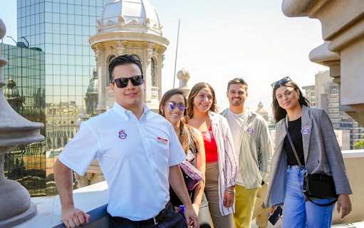 Guests with guide on Santiago Cathedral Bell Tower terrace with city view.