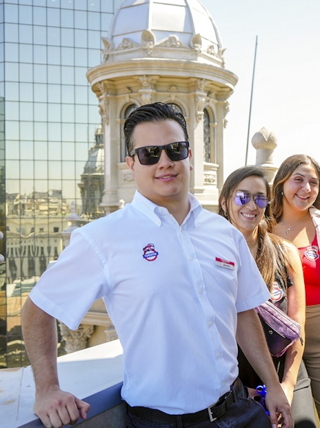 Guests with guide on Santiago Cathedral Bell Tower terrace with city view.