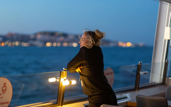 Person enjoying a sunset cruise on the Tagus River in Lisbon.