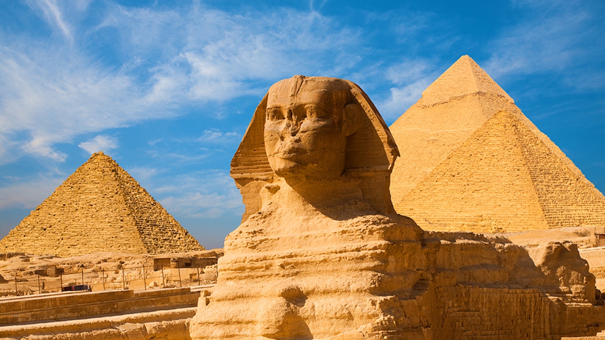 Sphinx and Pyramids of Giza under blue sky in Cairo, Egypt.