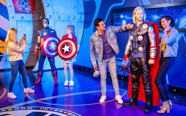 Visitors posing with Captain America and Thor wax figures at Madame Tussauds Hollywood.