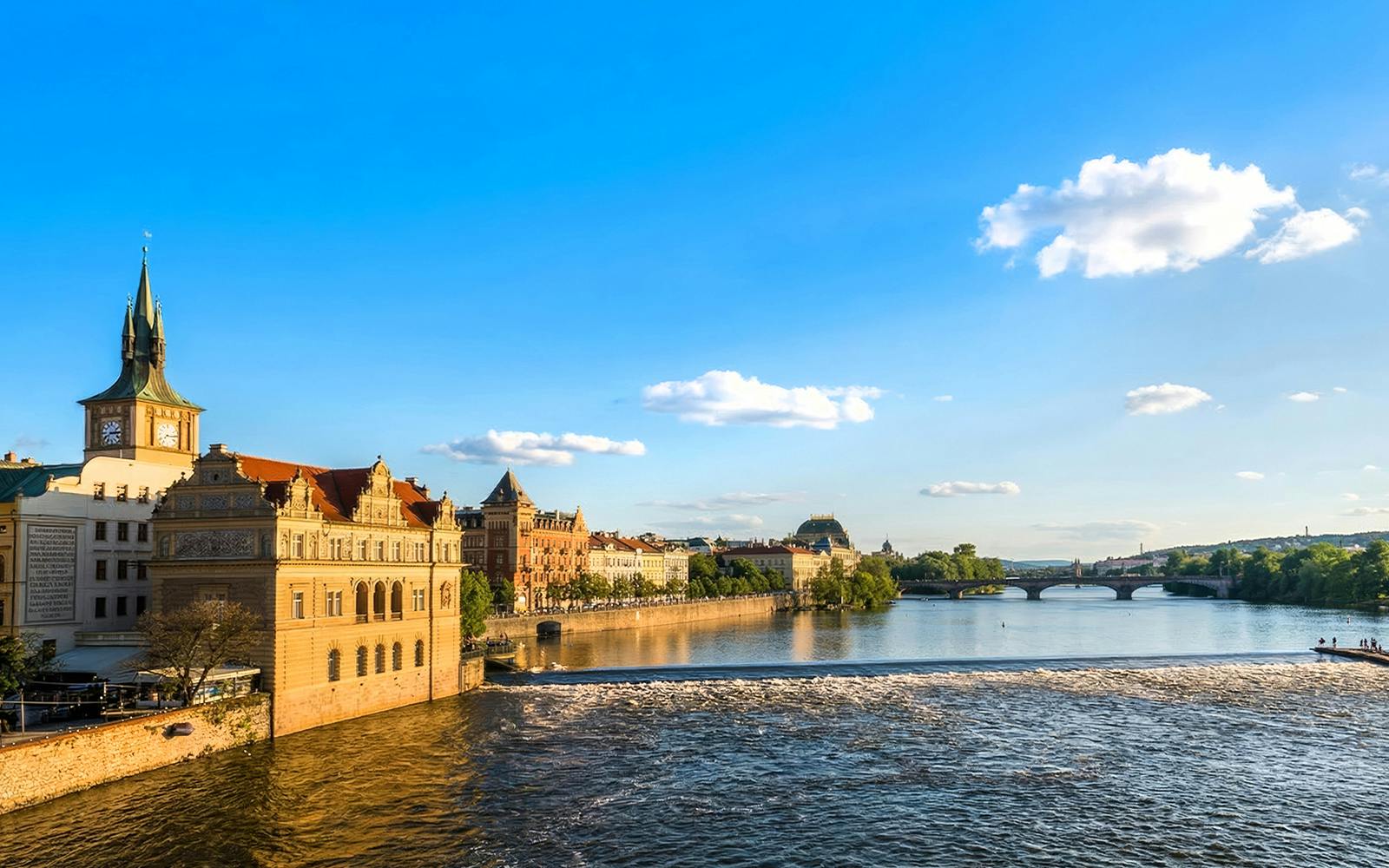 Vltava River in Prague with view of Charles Bridge and historic buildings.