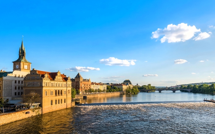 Vltava River in Prague with view of Charles Bridge and historic buildings.