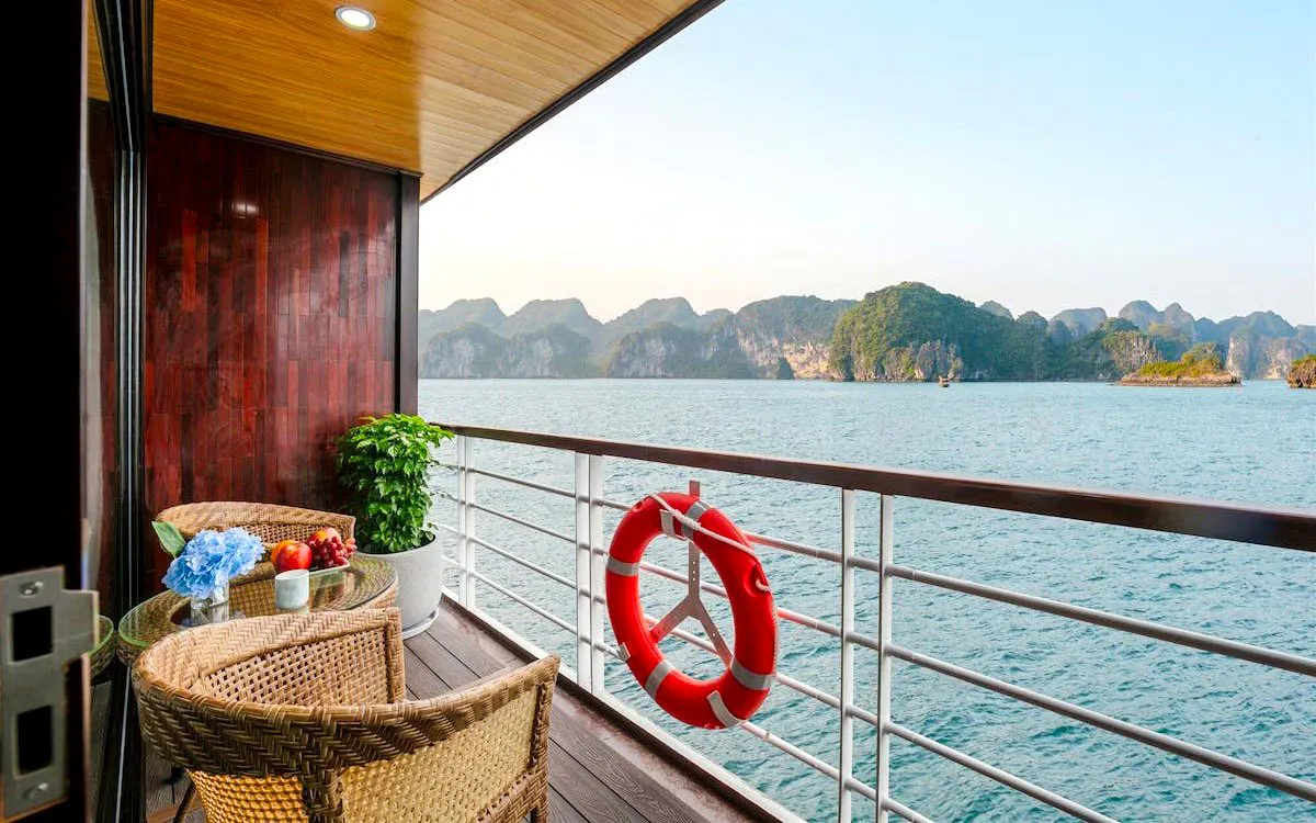 Balcony view from Du Junior Cabin on Ha Long Bay 5-Star Premium Cruise, featuring ocean and limestone islands.