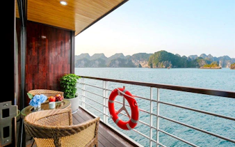 Balcony view from Du Junior Cabin on Ha Long Bay 5-Star Premium Cruise, featuring ocean and limestone islands.