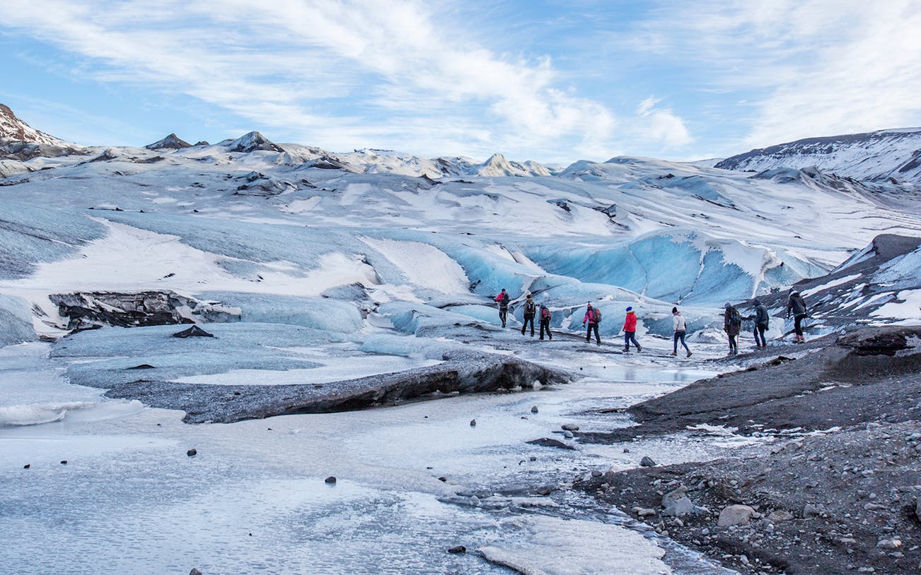 Group hiking on Sólheimajökull Glacier during South Coast Half Day Tour in Iceland.