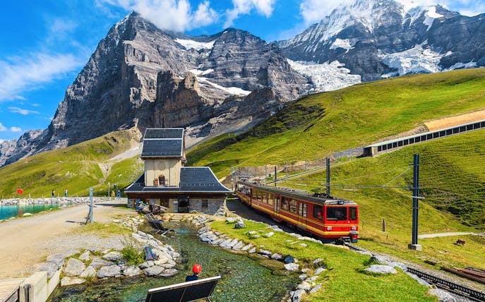 Train approaching Jungfraujoch station with mountain backdrop, Interlaken region.