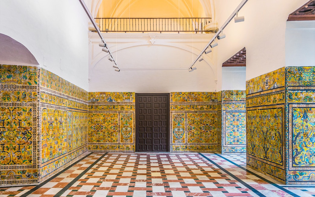 Alcazar of Seville interior with intricate tilework and arched ceiling.