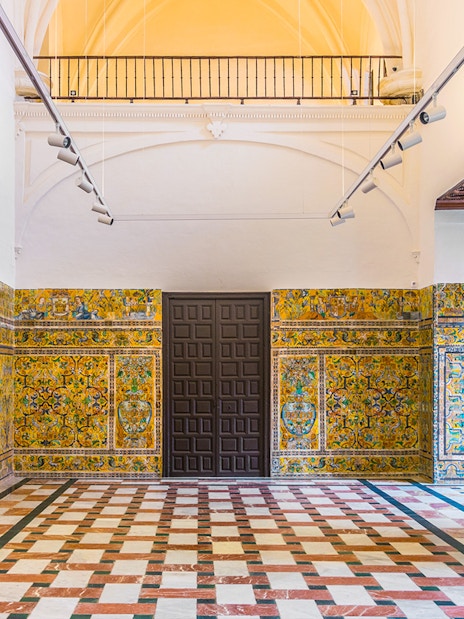 Alcazar of Seville interior with intricate tilework and arched ceiling.