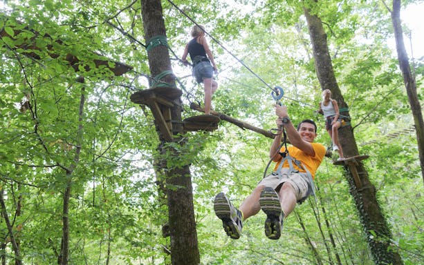 People ziplining through trees at Hanuman World Phuket.